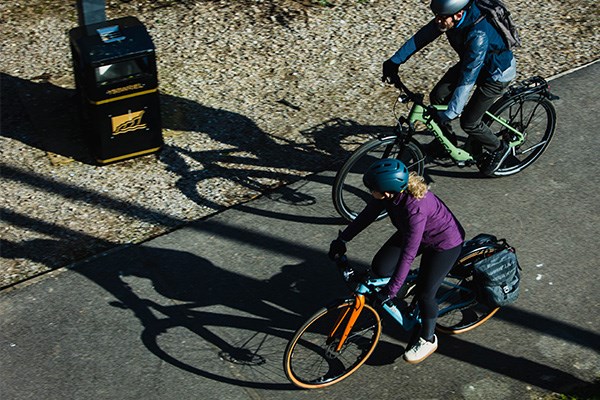 Orbea hybrid bikes being ridden in a park my mana and women